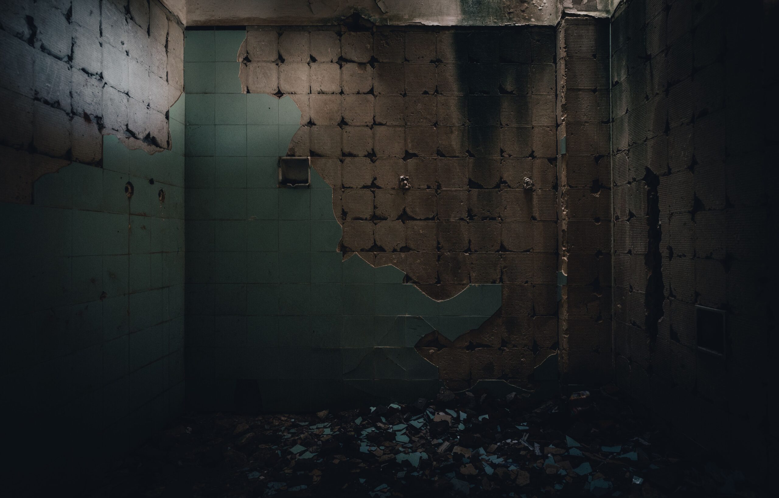 Dark, haunting interior of a vandalized and decaying room with eerie atmosphere.